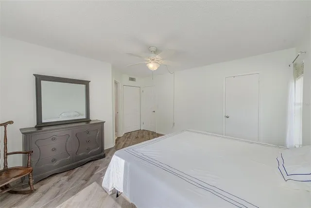 a view of a hallway with wooden floor and a potted plant