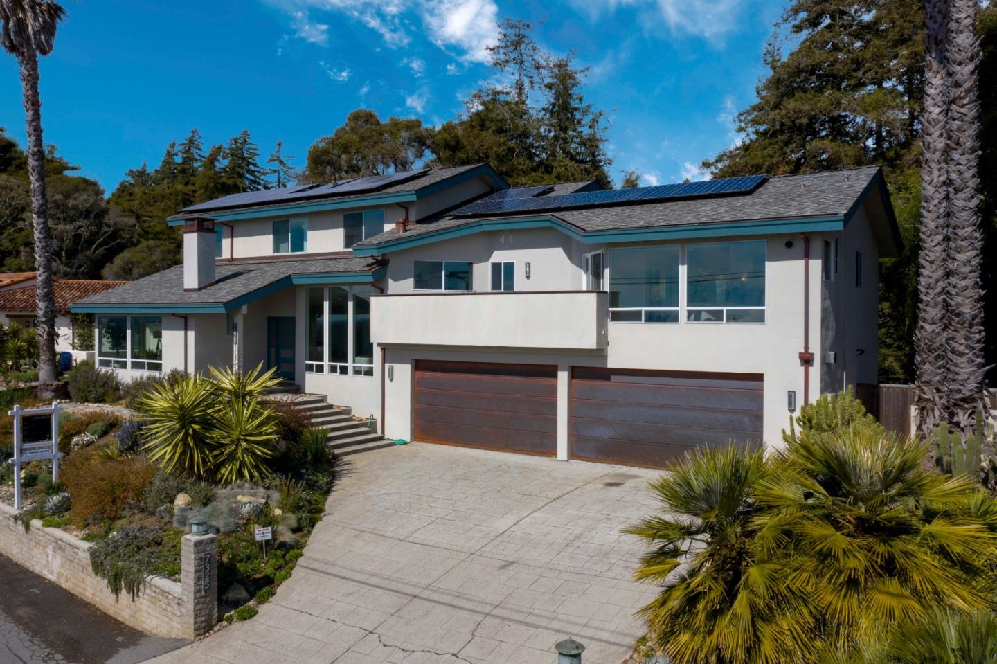 a front view of a house with a garden