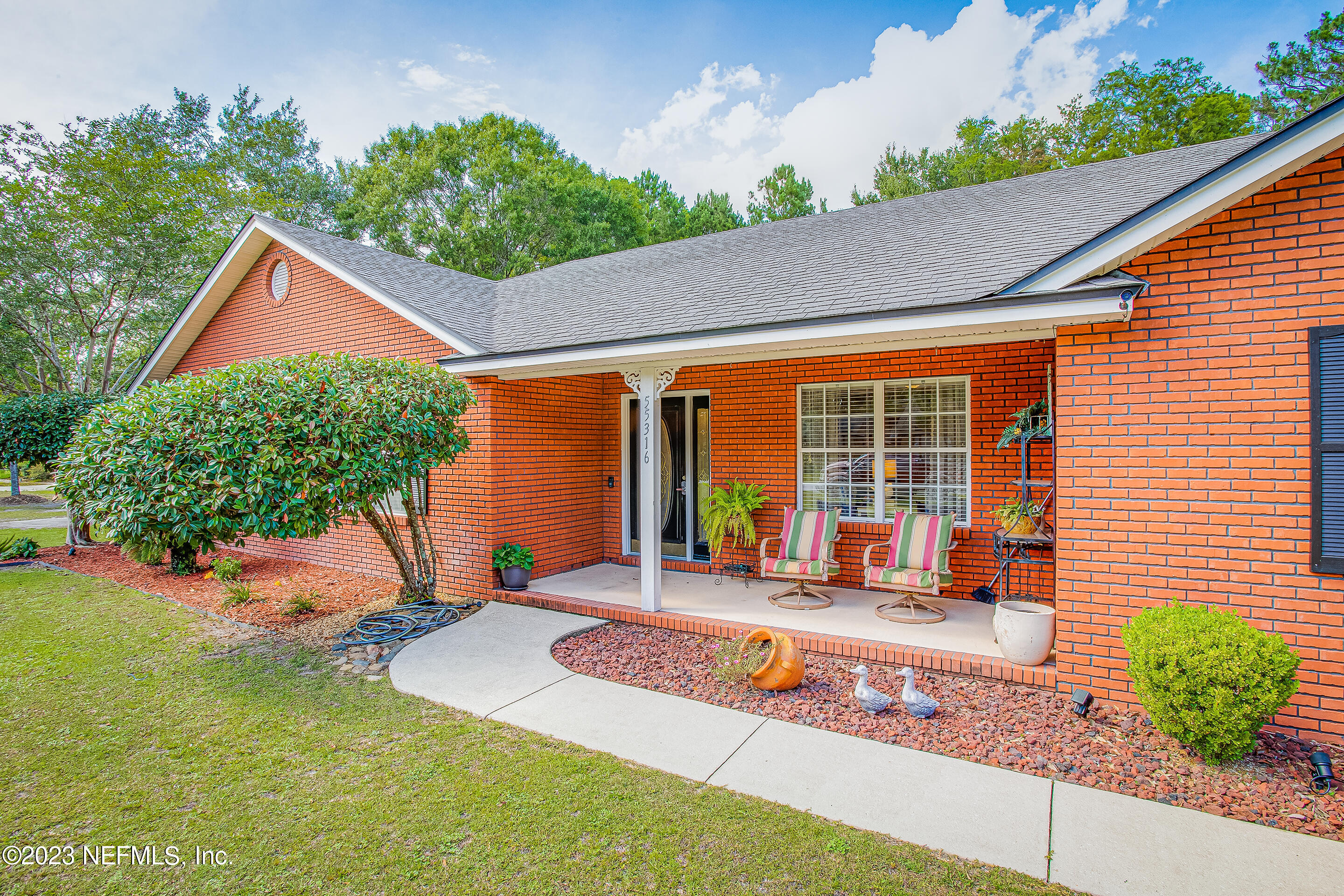 55316 Deer Run Road Callahan, FL 32011 - Photo 4 of 32 a front view of a house with a yard outdoor seating and covered with trees