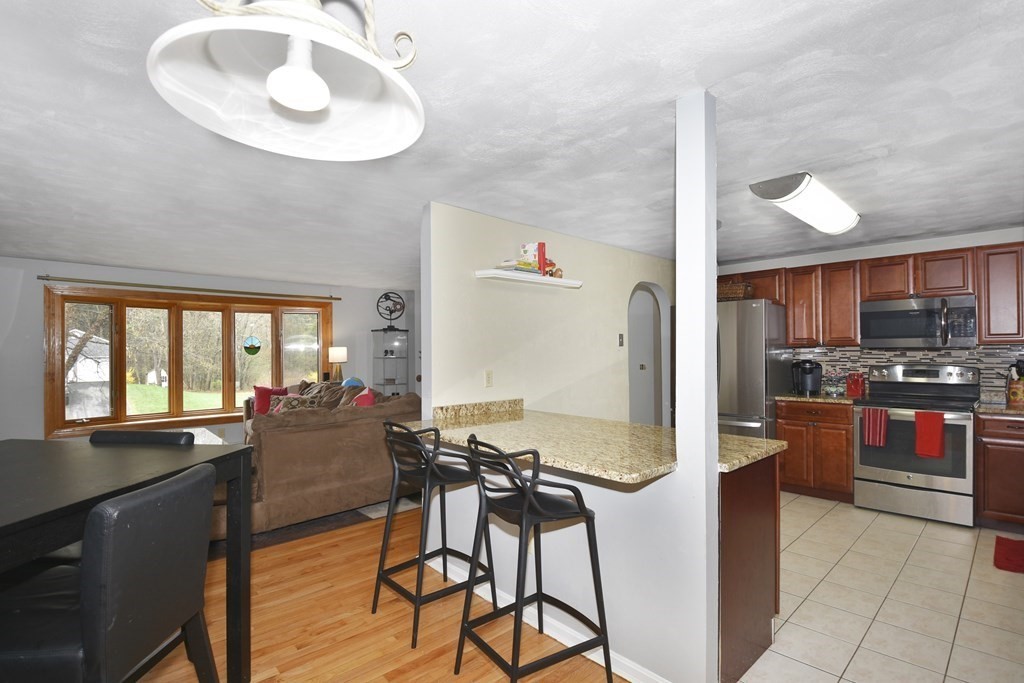 39 Tanglewood Road Sterling, MA 01564 - Photo 12 of 30 a kitchen with stainless steel appliances kitchen island granite countertop a stove and a refrigerator