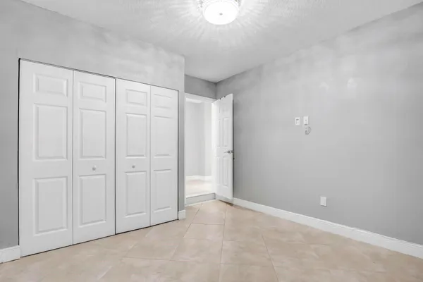 a spacious bathroom with double sink a toilet a mirror and shower