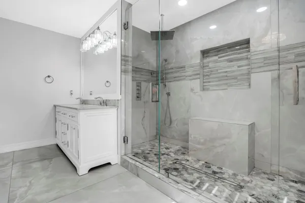 a bathroom with a granite countertop sink mirror vanity and toilet
