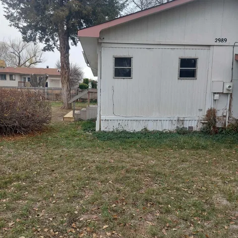 a backyard of a house with barbeque oven and table and chairs