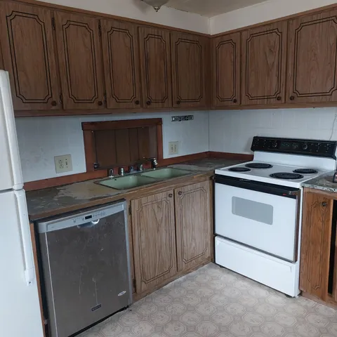 a kitchen with granite countertop wooden cabinets