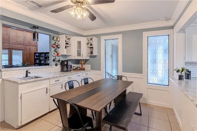 a kitchen with a table chairs sink and cabinets