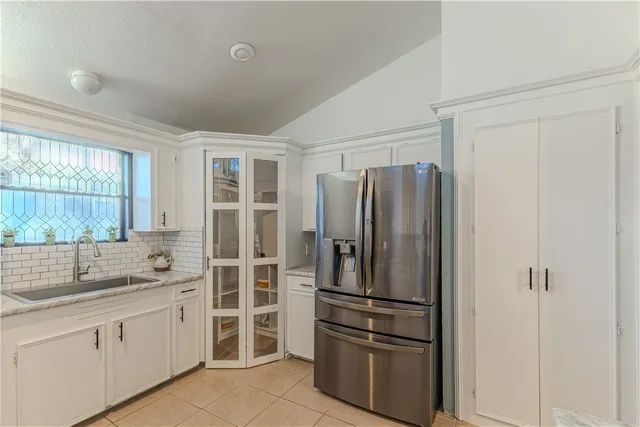 a kitchen with a refrigerator and windows