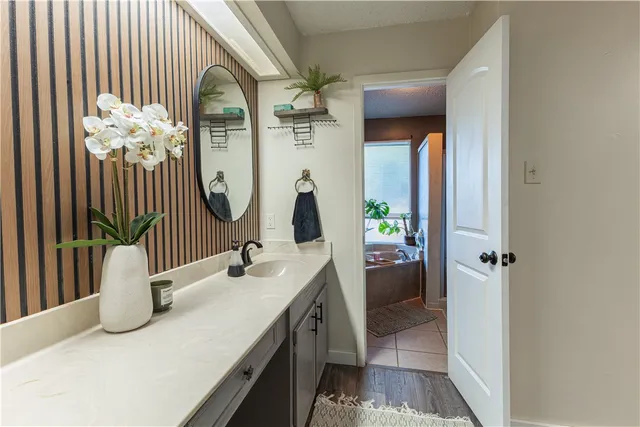 a en suite bathroom with a granite countertop sink and a mirror