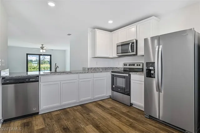a kitchen with stainless steel appliances granite countertop a refrigerator and a stove top oven