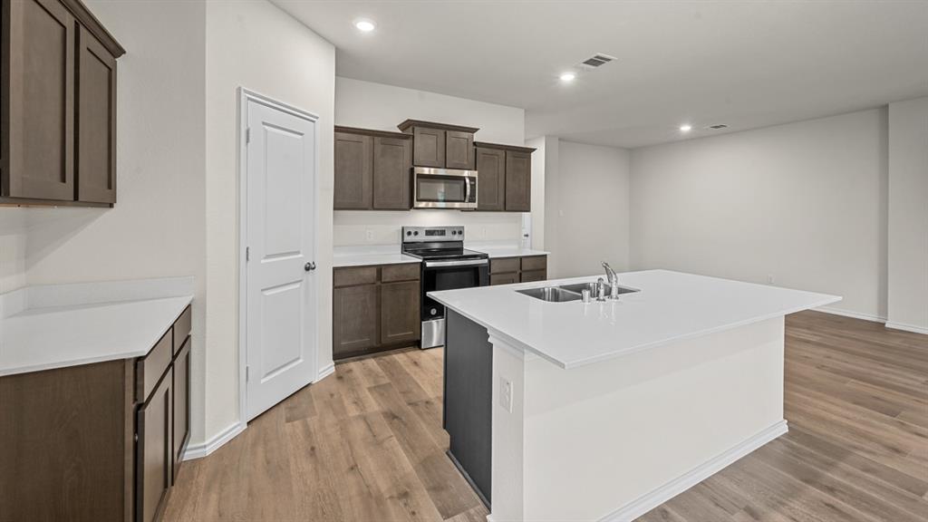 6088 Freedom Drive Lindale, TX 75706 - Photo 11 of 40 a kitchen with a sink a stove top oven and refrigerator