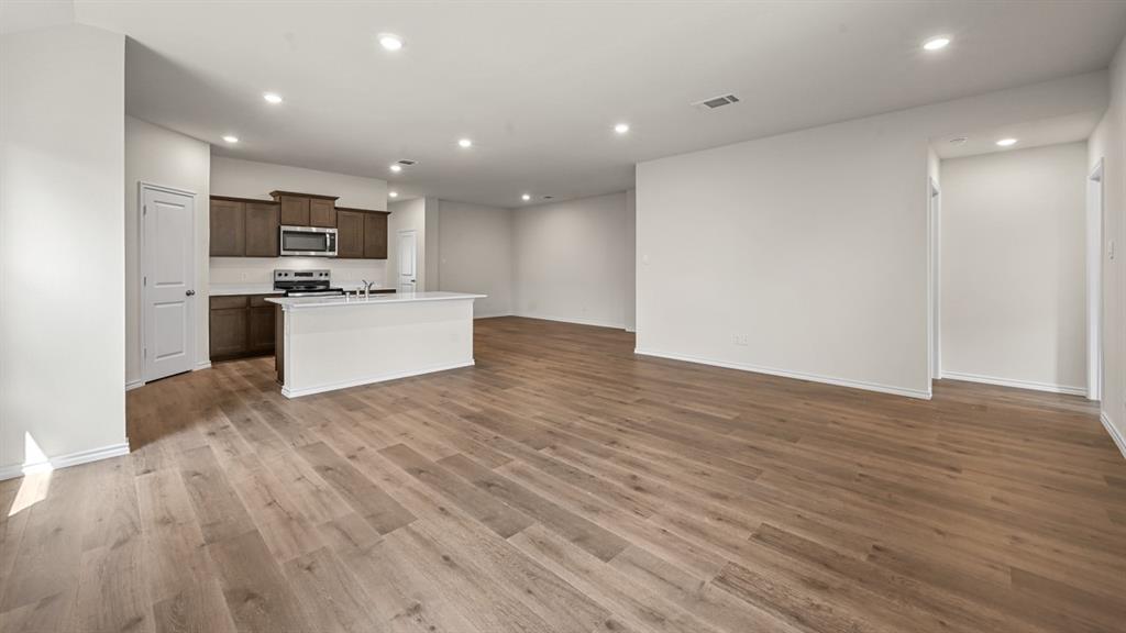 6088 Freedom Drive Lindale, TX 75706 - Photo 14 of 40 a view of living room with kitchen island stainless steel appliances wooden floor and living room view