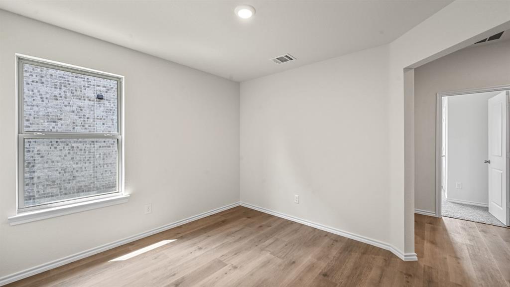 6088 Freedom Drive Lindale, TX 75706 - Photo 21 of 40 a view of an empty room with wooden floor and a window