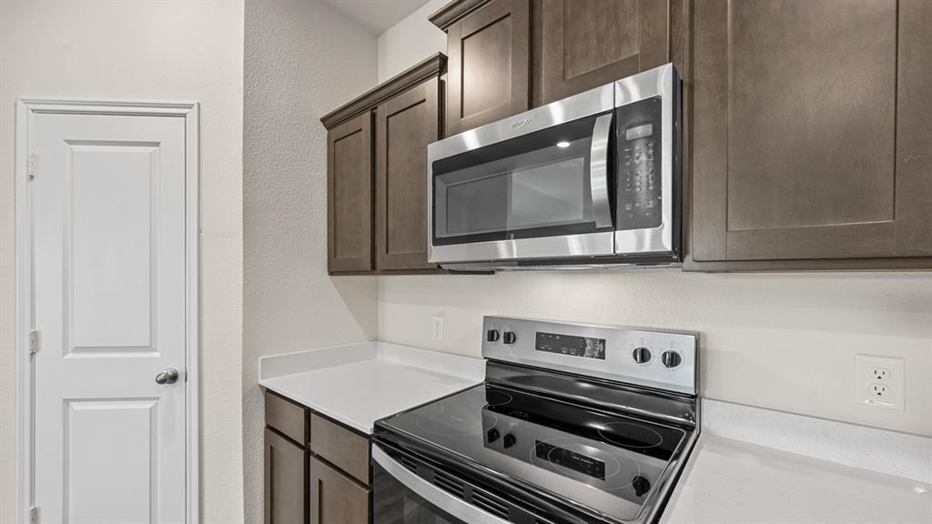 6088 Freedom Drive Lindale, TX 75706 - Photo 8 of 40 a kitchen with a stove and a microwave