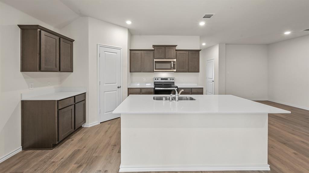 6088 Freedom Drive Lindale, TX 75706 - Photo 9 of 40 a large white kitchen with wooden floor