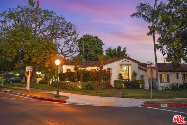 a front view of a house with a yard and tree s