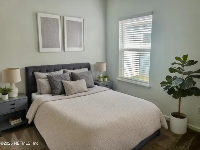 a bedroom with a bed and a potted plant