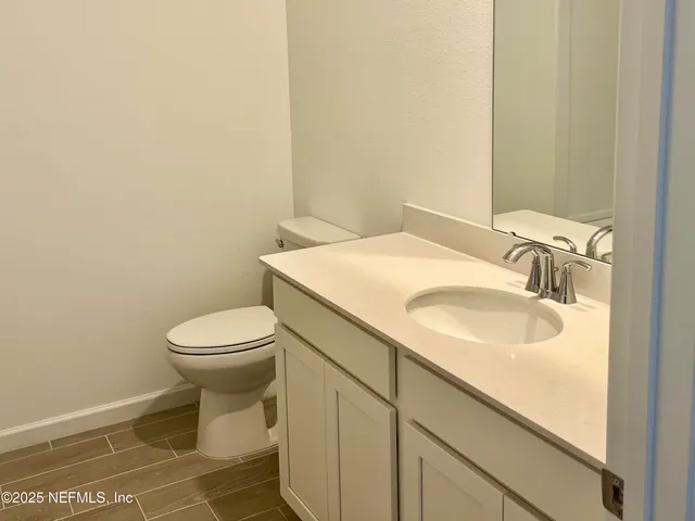 a bathroom with a granite countertop toilet and sink