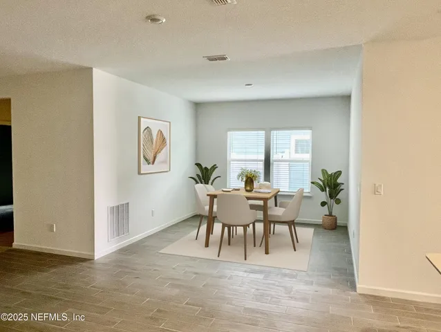 a view of a dining room with furniture and a potted plant