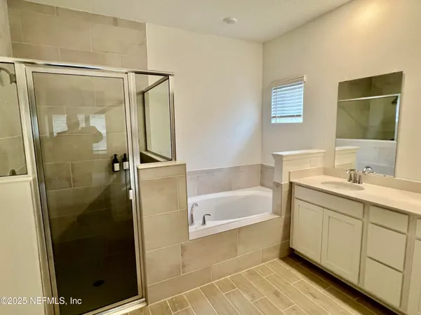 a bathroom with a bathtub a shower a sink and a window