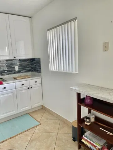 a room with white cabinets and clock on the wall