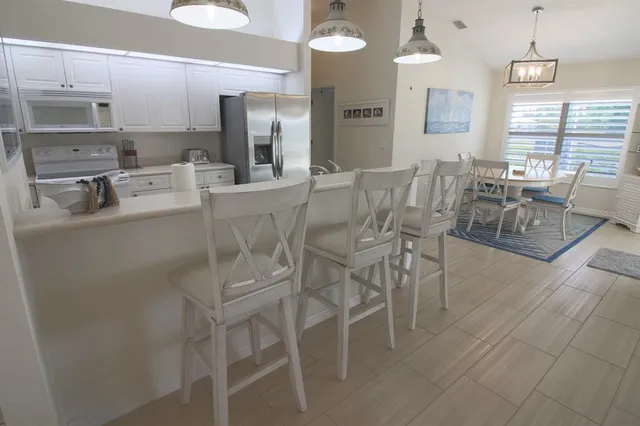 a kitchen with stainless steel appliances granite countertop white cabinets a refrigerator a sink and a stove