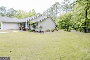 89 Copeland Road Newnan, GA 30263 - Photo 28 of 30 a view of a house with a yard and garage