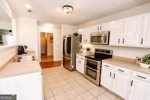 89 Copeland Road Newnan, GA 30263 - Photo 9 of 30 a kitchen with stainless steel appliances a stove microwave and sink