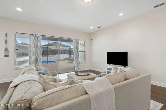 a living room with furniture a chandelier and a window