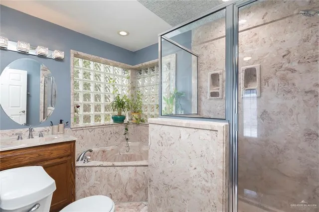 a bathroom with a granite countertop sink toilet a mirror and shower