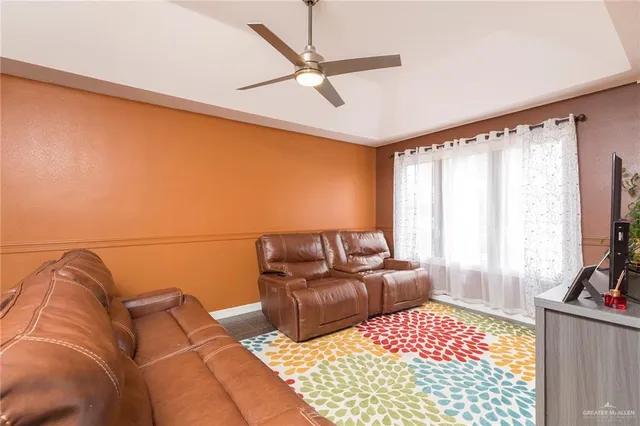 a living room with furniture ceiling fan and a rug