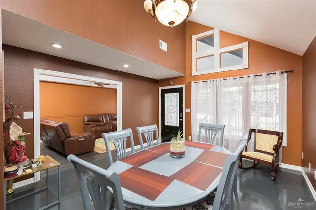 a view of a dining room with furniture a chandelier and wooden floor
