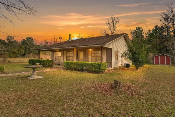 a view of a house with backyard and a tree