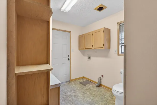 a bathroom with a granite countertop sink and a toilet