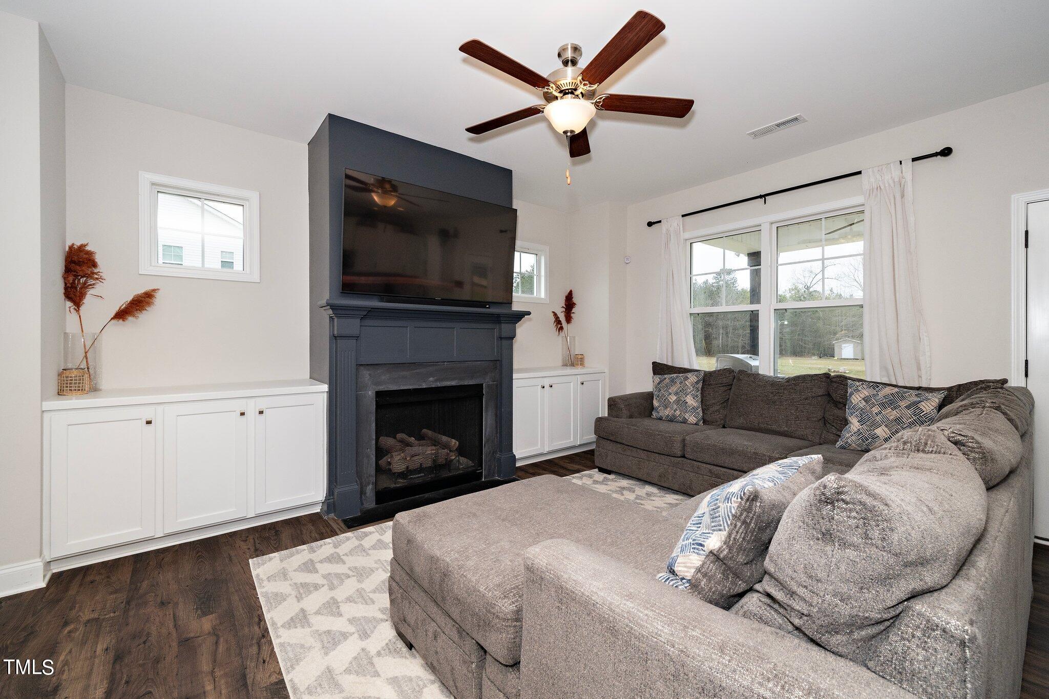 5944 Rosser Pittman Road Sanford, NC 27332 - Photo 5 of 13 a living room with furniture a flat screen tv and a fireplace