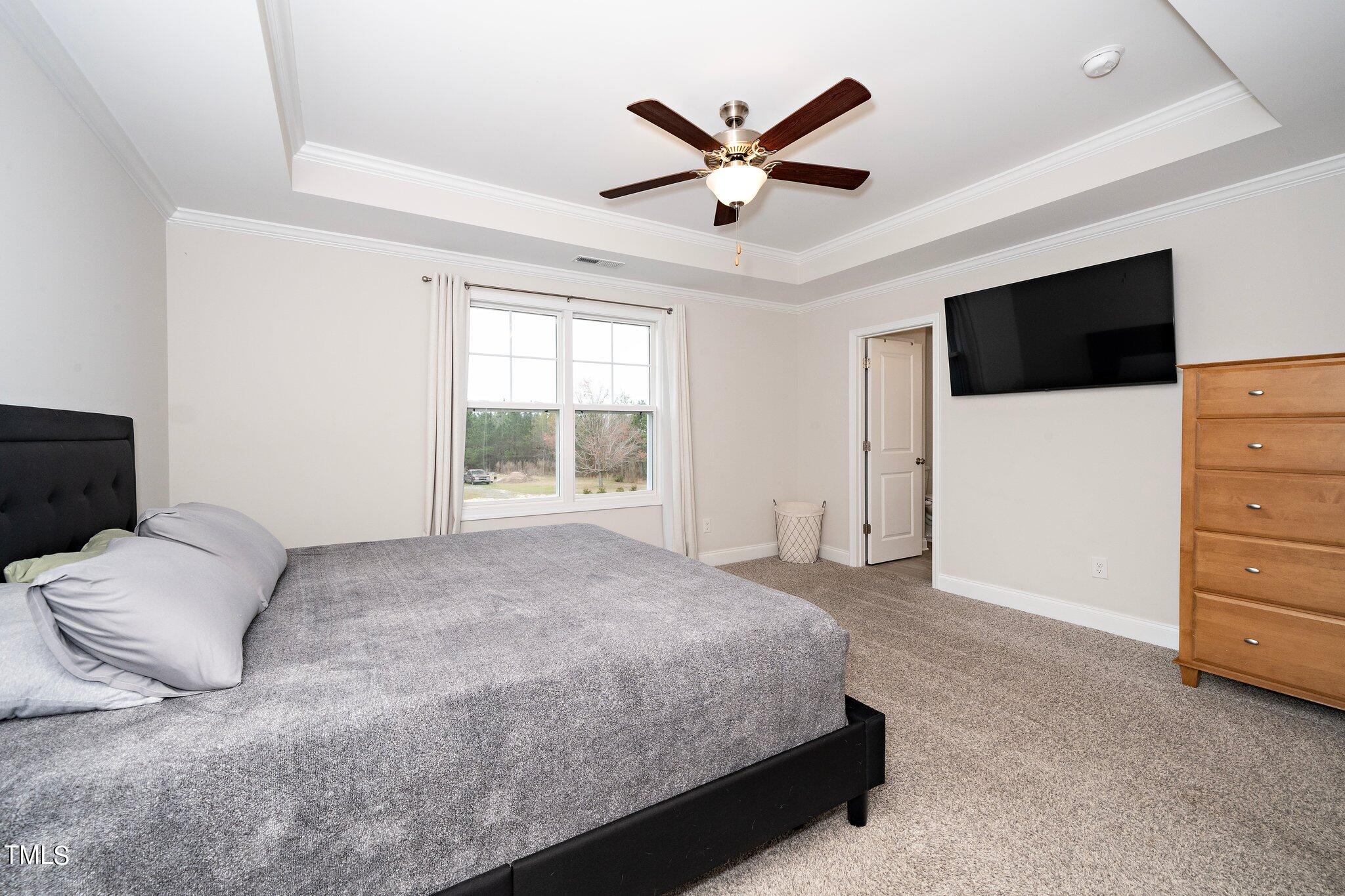 5944 Rosser Pittman Road Sanford, NC 27332 - Photo 7 of 13 a spacious bedroom with a bed and a flat screen tv