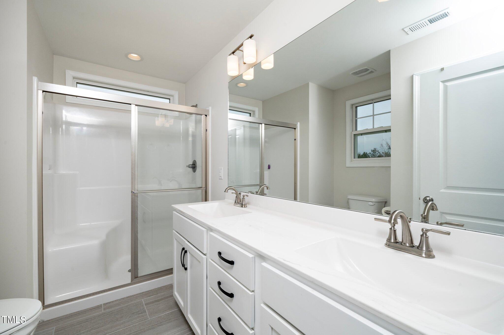 5944 Rosser Pittman Road Sanford, NC 27332 - Photo 9 of 13 a bathroom with a sink vanity granite tub shower and a mirror