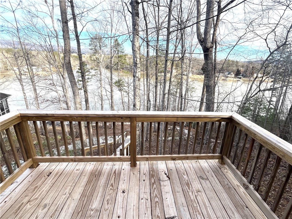 212 Whitewater Lake Road Tamassee, SC 29686 - Photo 7 of 9 A spacious wooden deck provides tranquil views of the surrounding natural landscape and distant waters.
