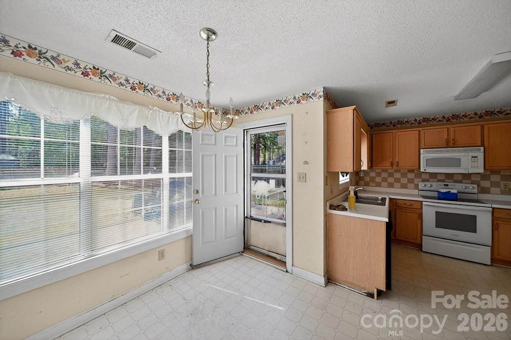 2205 Old Sparta Road Rocky Mount, NC 27804 - Photo 5 of 25 a kitchen with stainless steel appliances granite countertop a stove and a refrigerator
