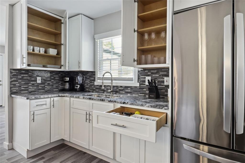 1561 Pontiac Place Southeast Atlanta, GA 30315 - Photo 3 of 14 a view of a kitchen with a sink and dishwasher a refrigerator with wooden floor