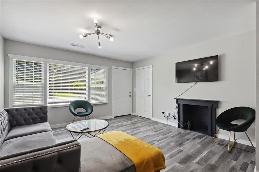 1561 Pontiac Place Southeast Atlanta, GA 30315 - Photo 5 of 14 a living room with furniture a fireplace and a flat screen tv