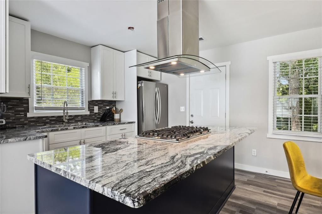 1561 Pontiac Place Southeast Atlanta, GA 30315 - Photo 8 of 14 a kitchen with granite countertop a sink a stove and a wooden cabinets