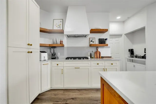 a kitchen with stainless steel appliances a stove a sink and white cabinets