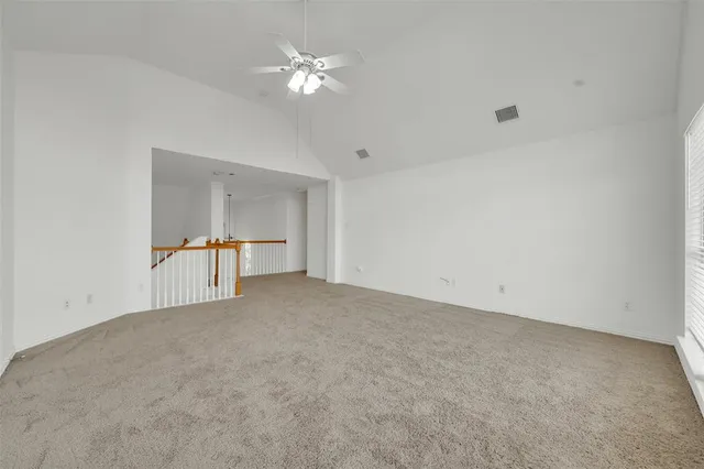 a view of an empty room with a chandelier fan