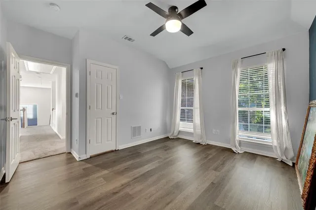 a view of a livingroom with wooden floor and a ceiling fan