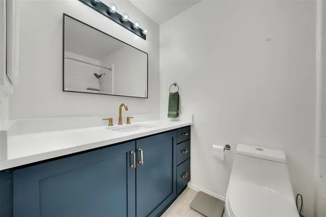 a bathroom with a sink a toilet and mirror