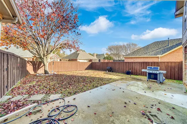 a view of a backyard with wooden fence