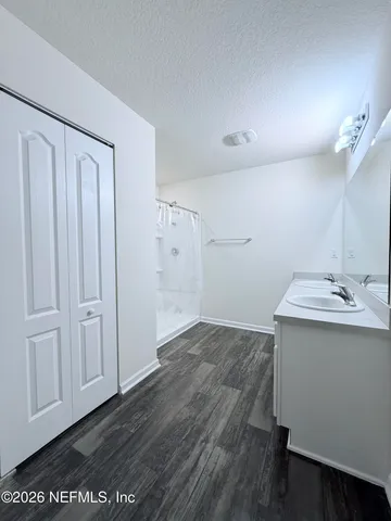 a view of a kitchen with a sink and dishwasher with wooden floor