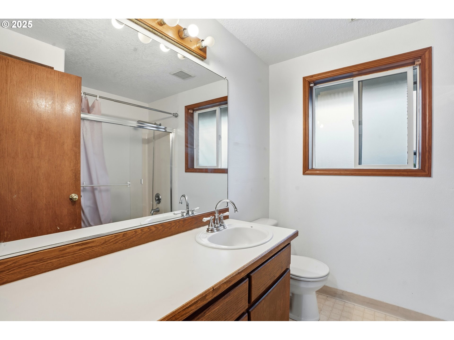 4724 Southeast Powell Valley Road Gresham, OR 97080 - Photo 18 of 28 a bathroom with a sink a mirror and a toilet