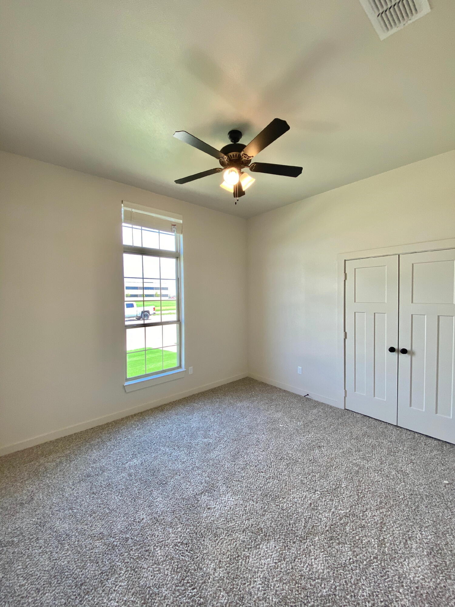 2729 137th Street Lubbock, TX 79423 - Photo 5 of 12 an empty room with windows and fan