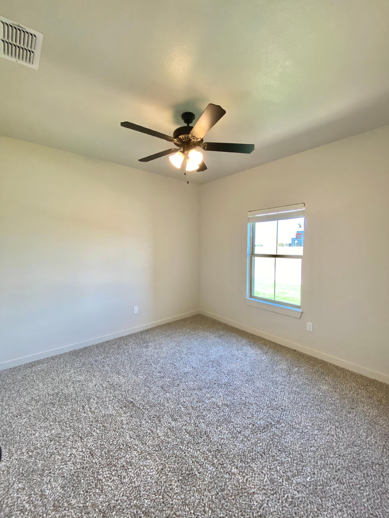 2729 137th Street Lubbock, TX 79423 - Photo 7 of 12 an empty room with windows and ceiling fan