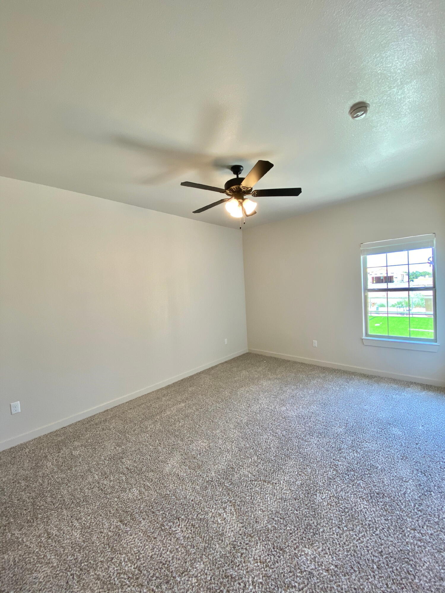 2729 137th Street Lubbock, TX 79423 - Photo 8 of 12 an empty room with windows and fan